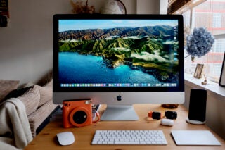 Front view of a completely set-up iMac on a table with accessories