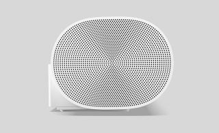 Side edge view of a white Sonos Arc sounbar placed on a silver background